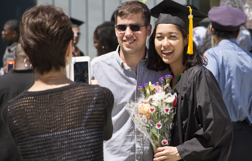 Two graduates holding flowers