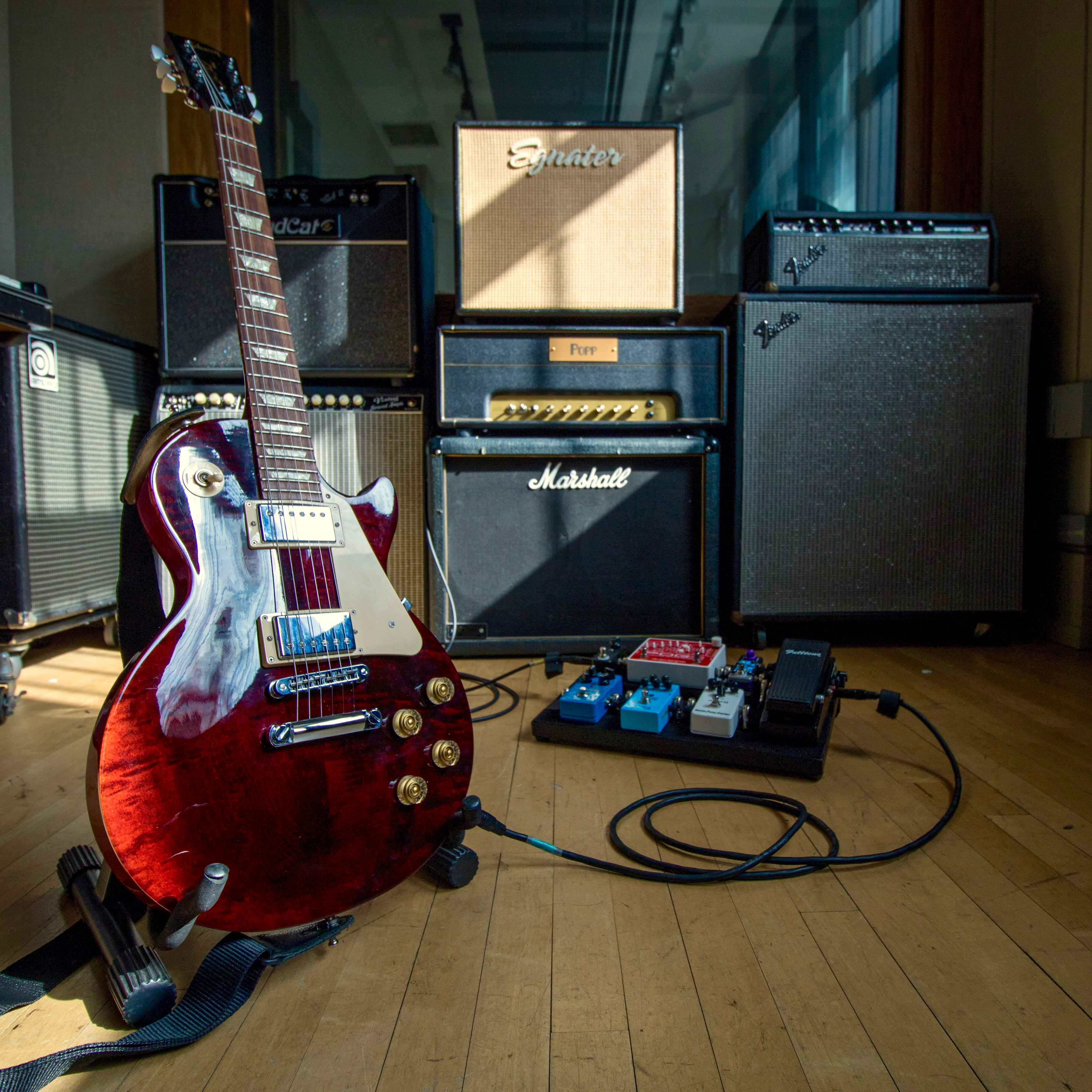 Les Paul Electric guitar with pedalboard and collection of guitar and bass amplifiers