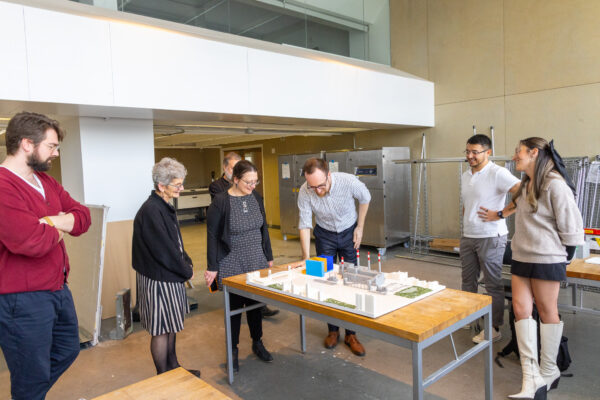 A group of people standing around a table admiring the 3D Ravenswood model.
