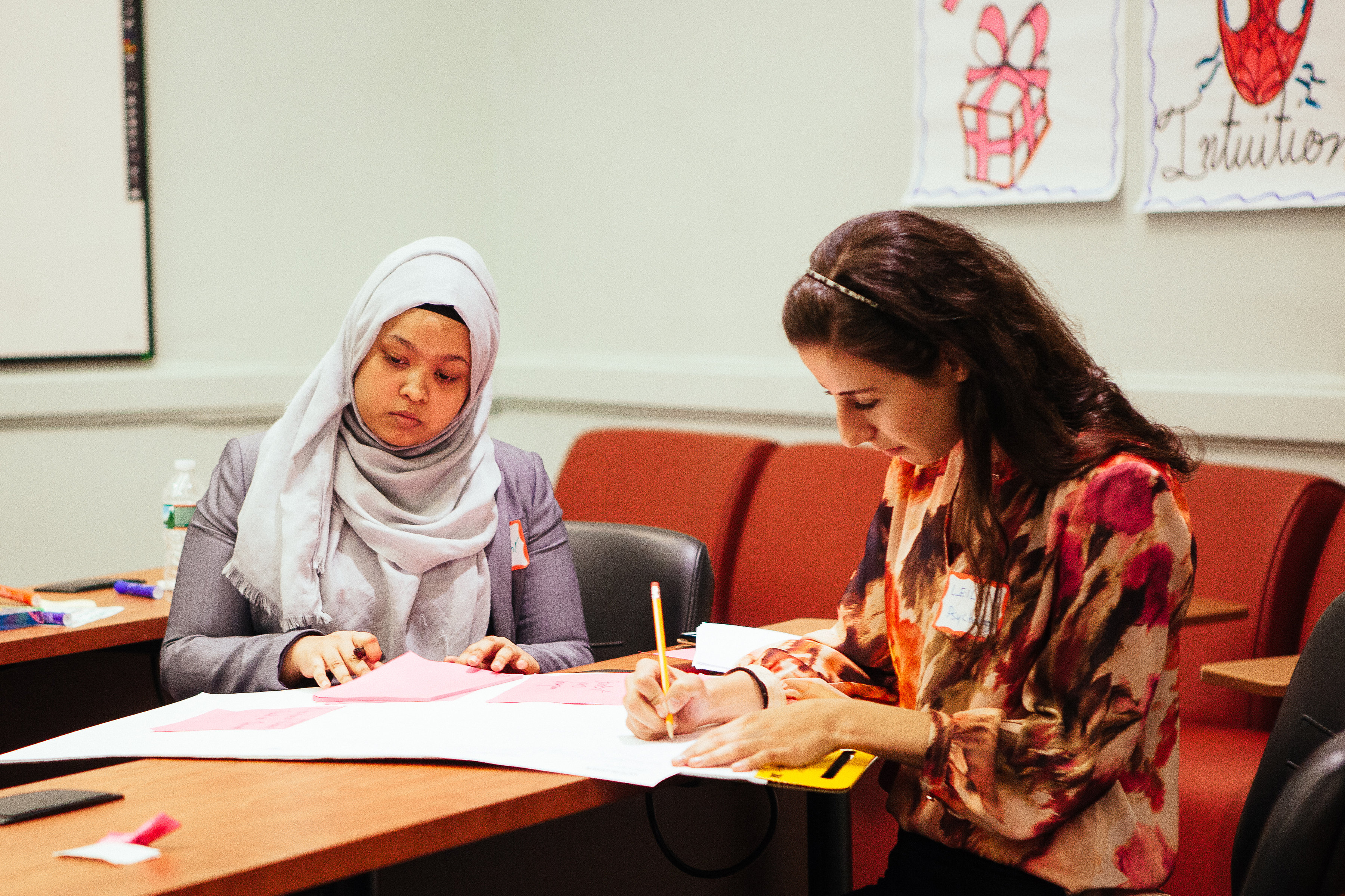 Young women study financials in a classroom.