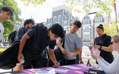 Group of students and alumni signing up