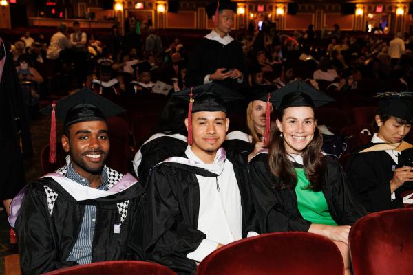 Group of Graduate Students sit and smile at the United Palace Theater