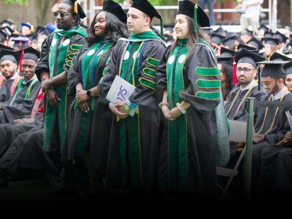CCNY Graduates standing at the Commencement Ceremony