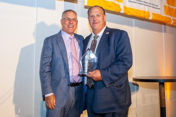 CCNY President Vincent Boudreau [left] receives the 2025 Building Futures Award from BCTC President Gary LaBarbera.  