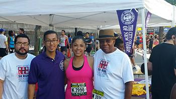 Sarai Perez (second from the right) and fellow runners at the CCNY information booth before the 5K run.