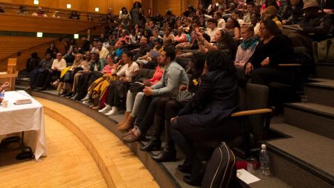 Chinua Achebe Legacy Series talking to a full theater of students 