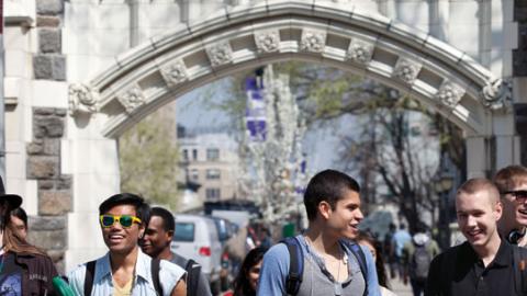 Photo of a group of students walking to class under the archway