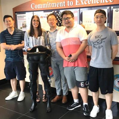 CCNY Mechanical Engineering Professor Hao Su [third from left] with members of his research team and a model of their exoskeleton.