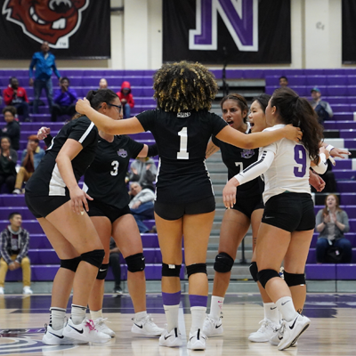 CCNY's volleyball team huddle 