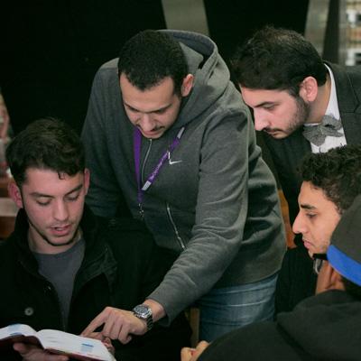 Group of students reading a book 